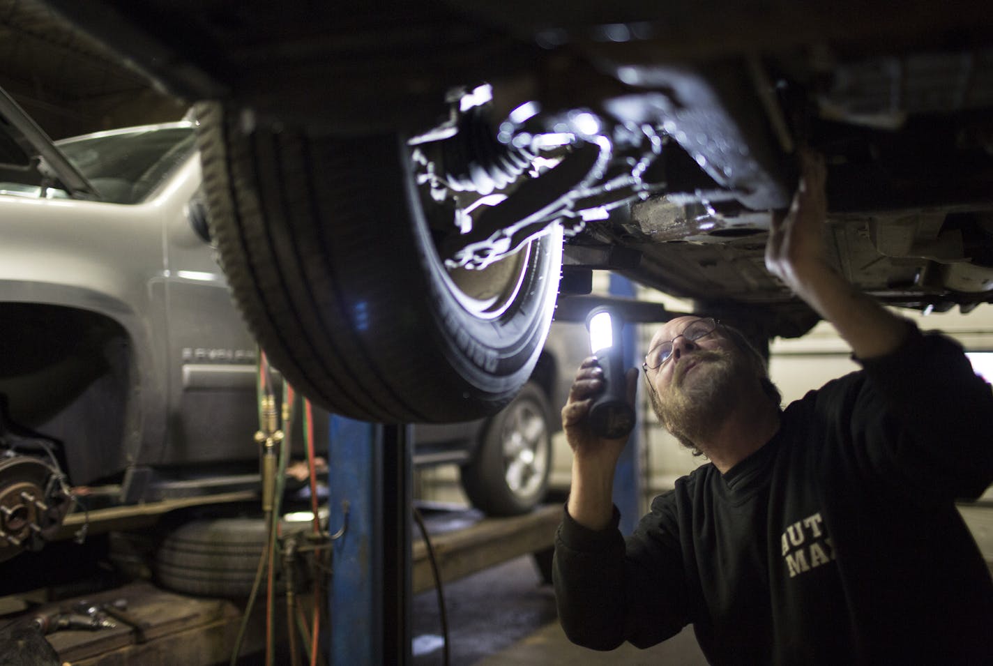 Drew Mickelson checked on the antilock brake system on a car at Auto Max on Dec. 11 in Columbia Heights.