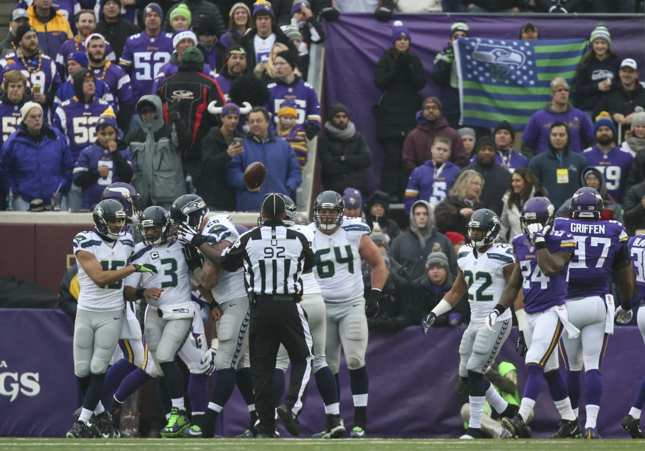 Seahawks quarterback Russell Wilson (3) was congratulated by teammates J.R. Sweezy (64) and Jermaine Kearse (15) after his eight yard touchdown run in the second quarter Sunday.