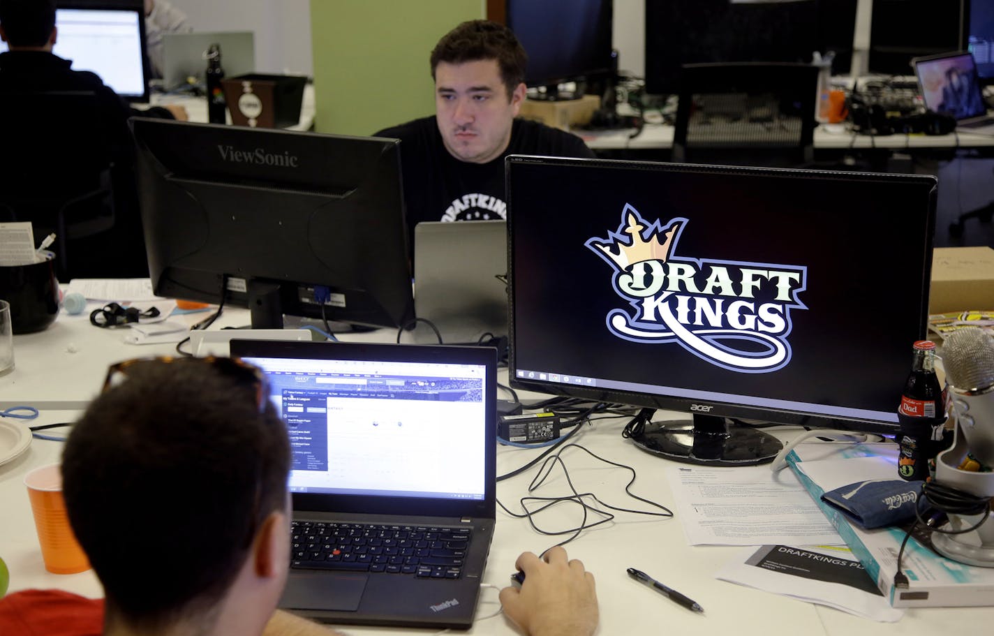 In this Wednesday, Sept. 9, 2015, photo, Len Don Diego, marketing manager for content at DraftKings, a daily fantasy sports company, works at his station at the company's offices in Boston. The daily fantasy sports industry is eyeing a breakout season as NFL games begin. And its two dominant companies, DraftKings and FanDuel, are touting lucrative opening week prizes to try to draw more customers as more competitors pop up. (AP Photo/Stephan Savoia) ORG XMIT: MIN2015092217104777