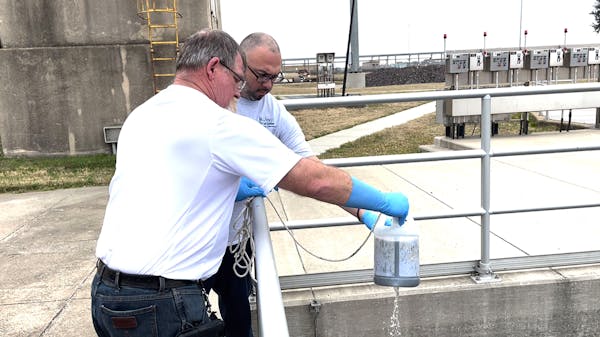 Larry Middleton, front, operations supervisor of Central Wastewater Treatment Plant in Dallas, poured wastewater into a pot to obtain fecal samples fo