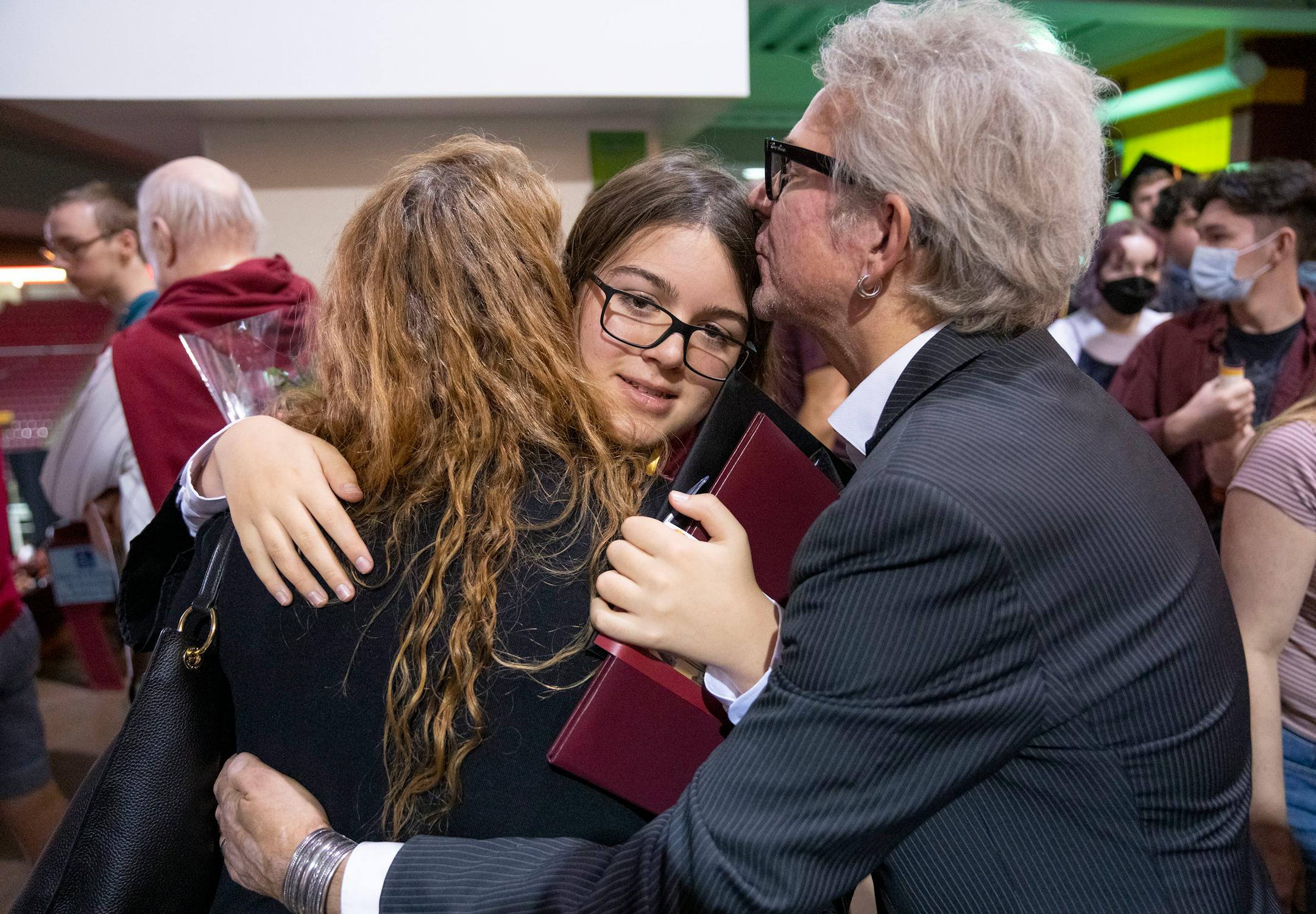 Michelle and Patrik Tanner embrace their son, Elliott, 13, after his graduation.