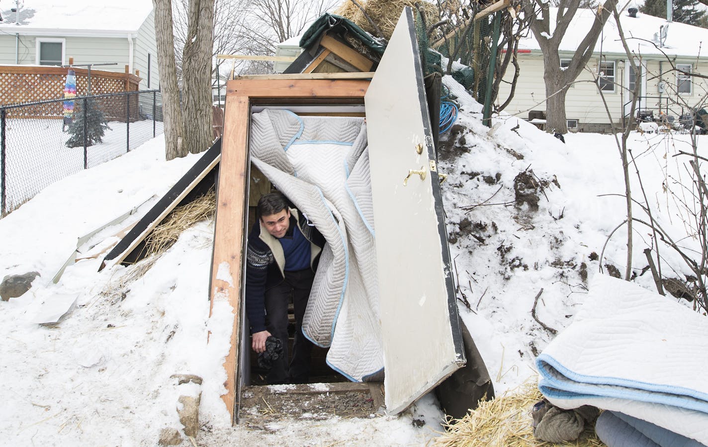 Greg Strong emerges from inside a Walipini, an underground greenhouse, in Minneapolis.