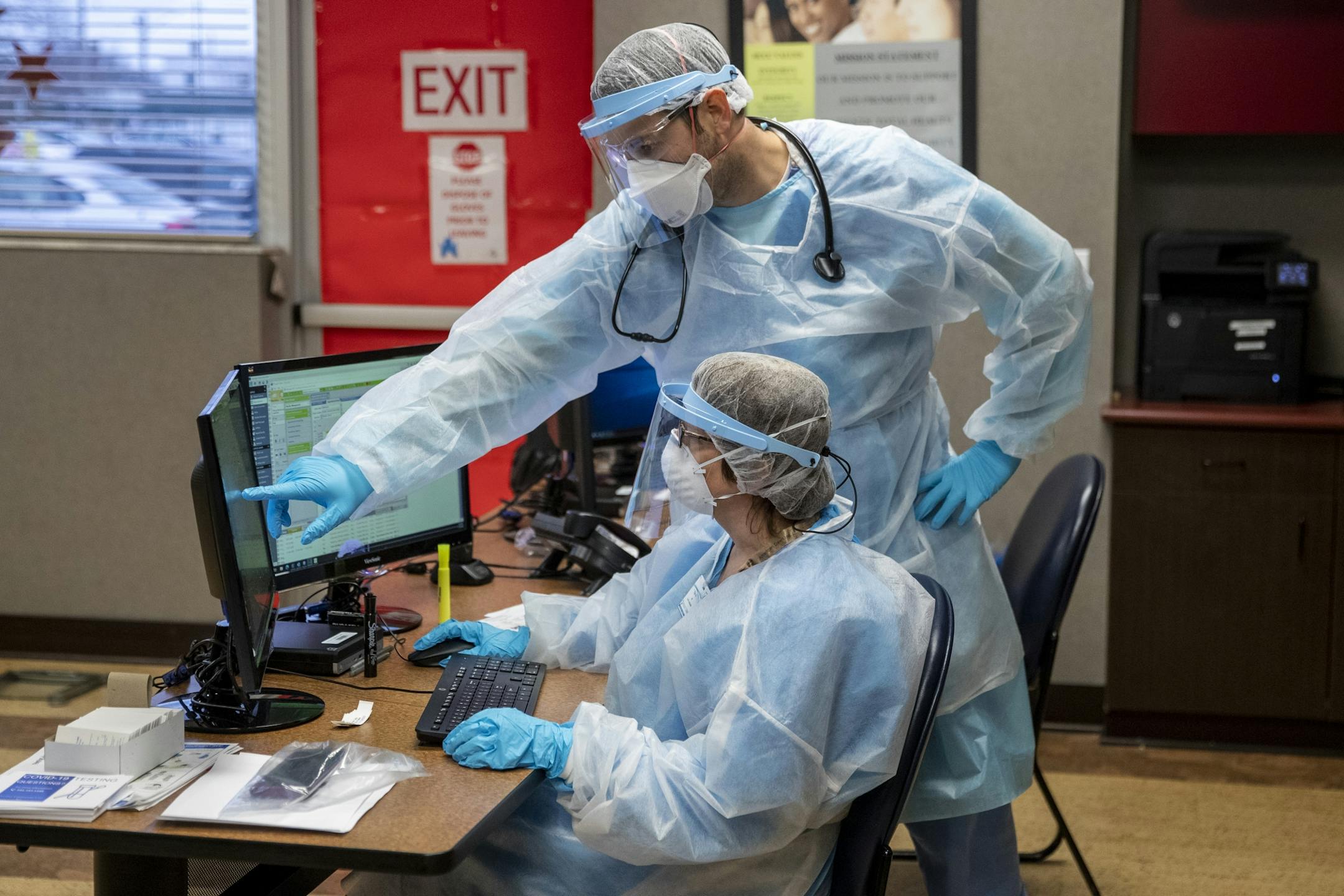 Physician assistant Steven Oginsky, top, and registered nurse Kim Alder work inside the Hackley Community Care COVID-19 triage room at 2700 Baker Street in Muskegon Heights, Mich., Friday, Nov. 13, 2020.