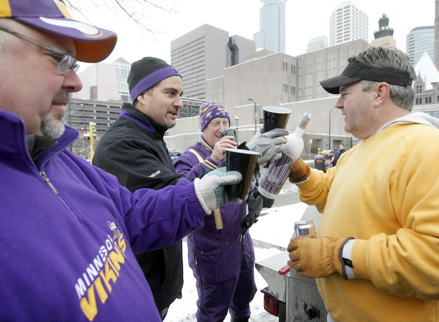 Paul Thielman (left) shared a toast with friends as they tailgated.