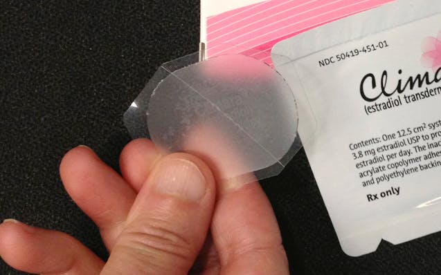 Close-up of hand holding low-dose estrogen skin patch.