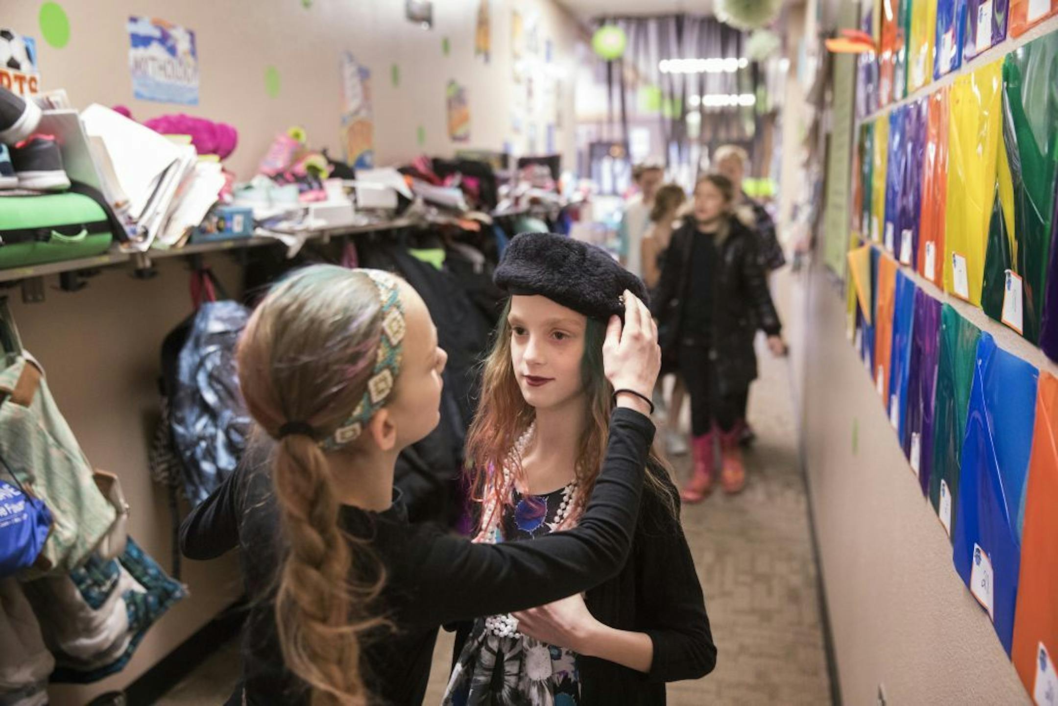 Isabelle, left, dressed as Marie Curie, helps her sister Abby adjust her Jackie Kennedy costume for a school history presentation that the fifth-graders were giving that day.