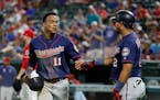 Minnesota Twins' Jorge Polanco (11) and Luis Arraez (2) celebrate after Polanco scored during the eighth inning of the team's baseball game against th