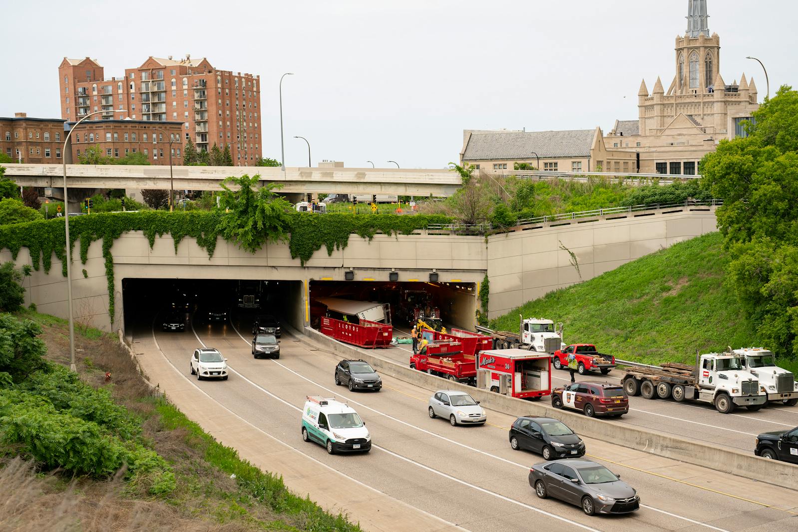 Workers clear debris Friday from Interstate 94 after a semitrailer truck crash in the Lowry Hill tunnel in Minneapolis.