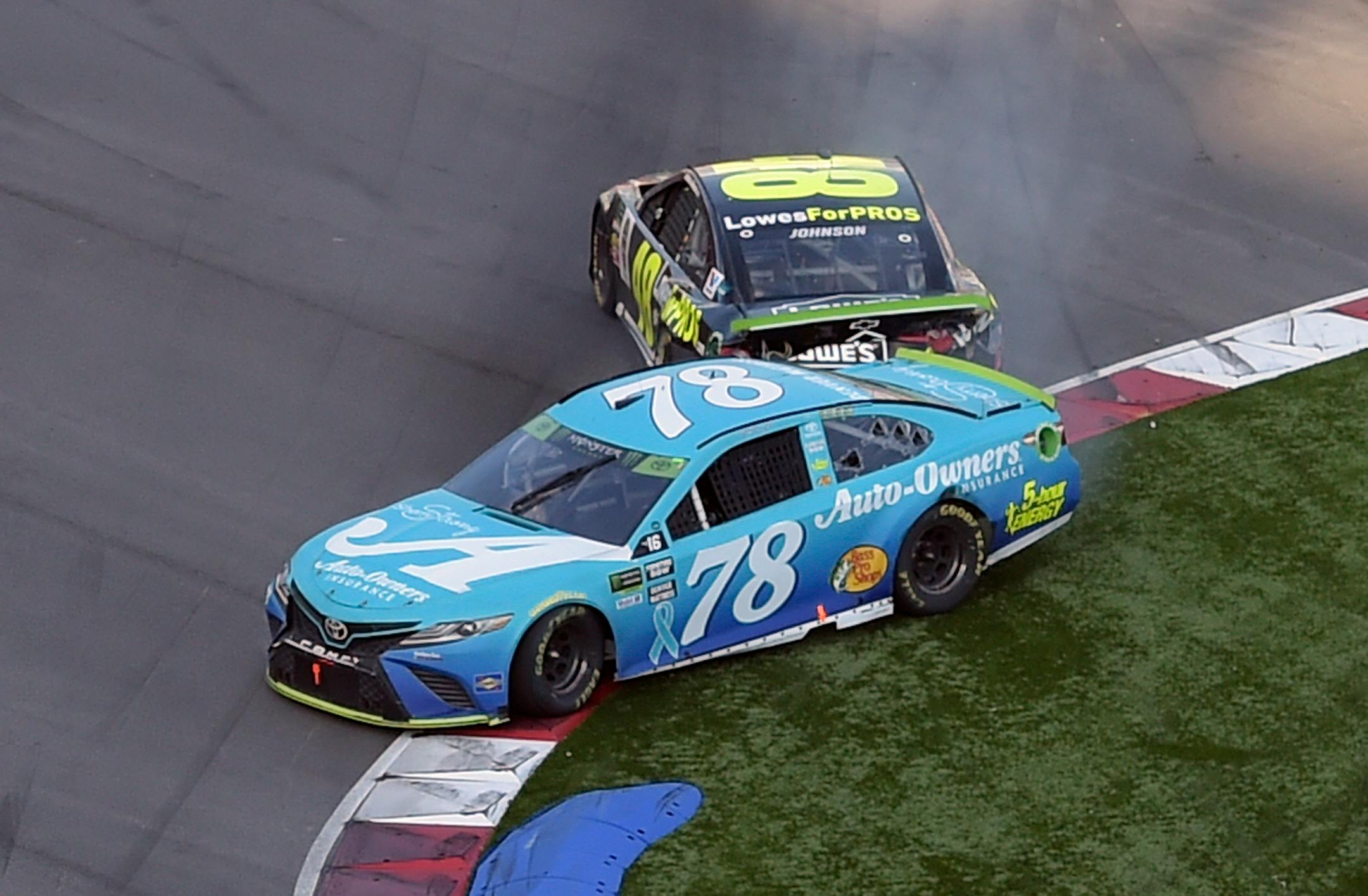 Martin Truex Jr. (78) was hit by Jimmie Johnson in the last lap of the NASCAR Cup series race at Charlotte Motor Speedway in Concord, N.C., on Sunday, allowing Ryan Blaney to slip by to win the race and cost Johnson a spot in the playoffs.