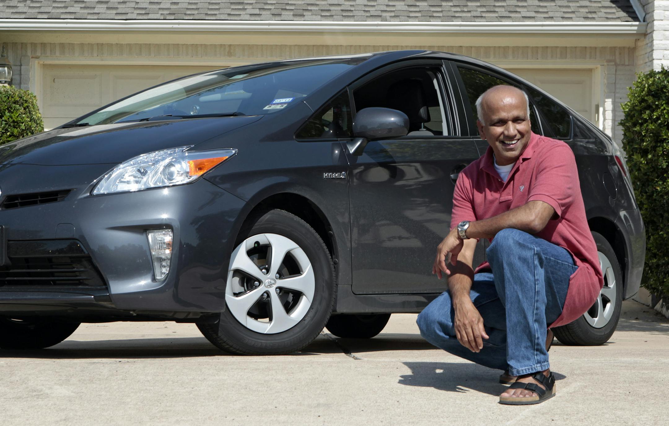 Pandian Athirajan next to his Toyota Prius Hybrid that he bought in May, in Austin, Texas, Aug. 1, 2013.