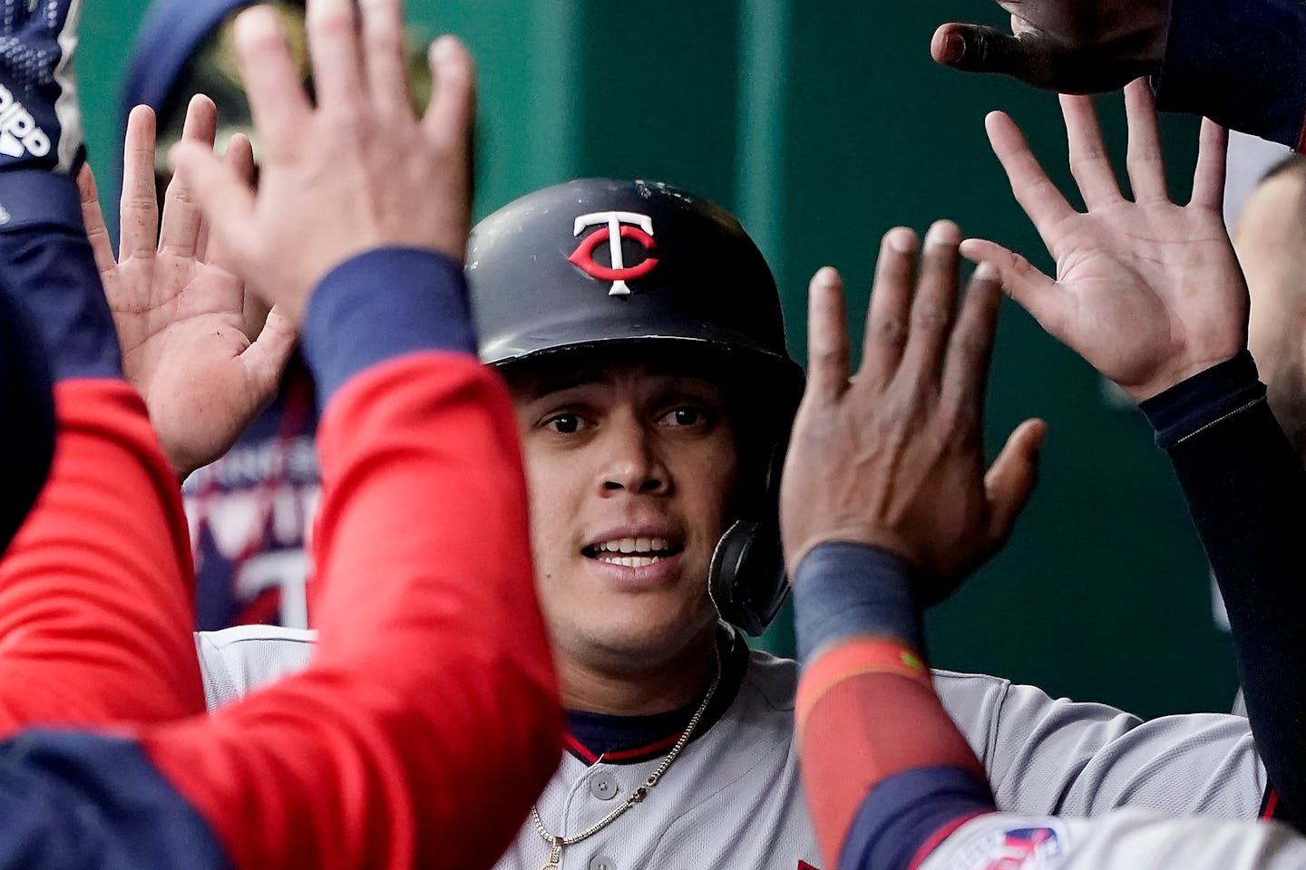 Minnesota Twins' Gio Urshela celebrates in the dugout after scoring on a sacrifice fly by Byron Buxton during the third inning of a baseball game Saturday, May 21, 2022, in Kansas City, Mo. (AP Photo/Charlie Riedel)