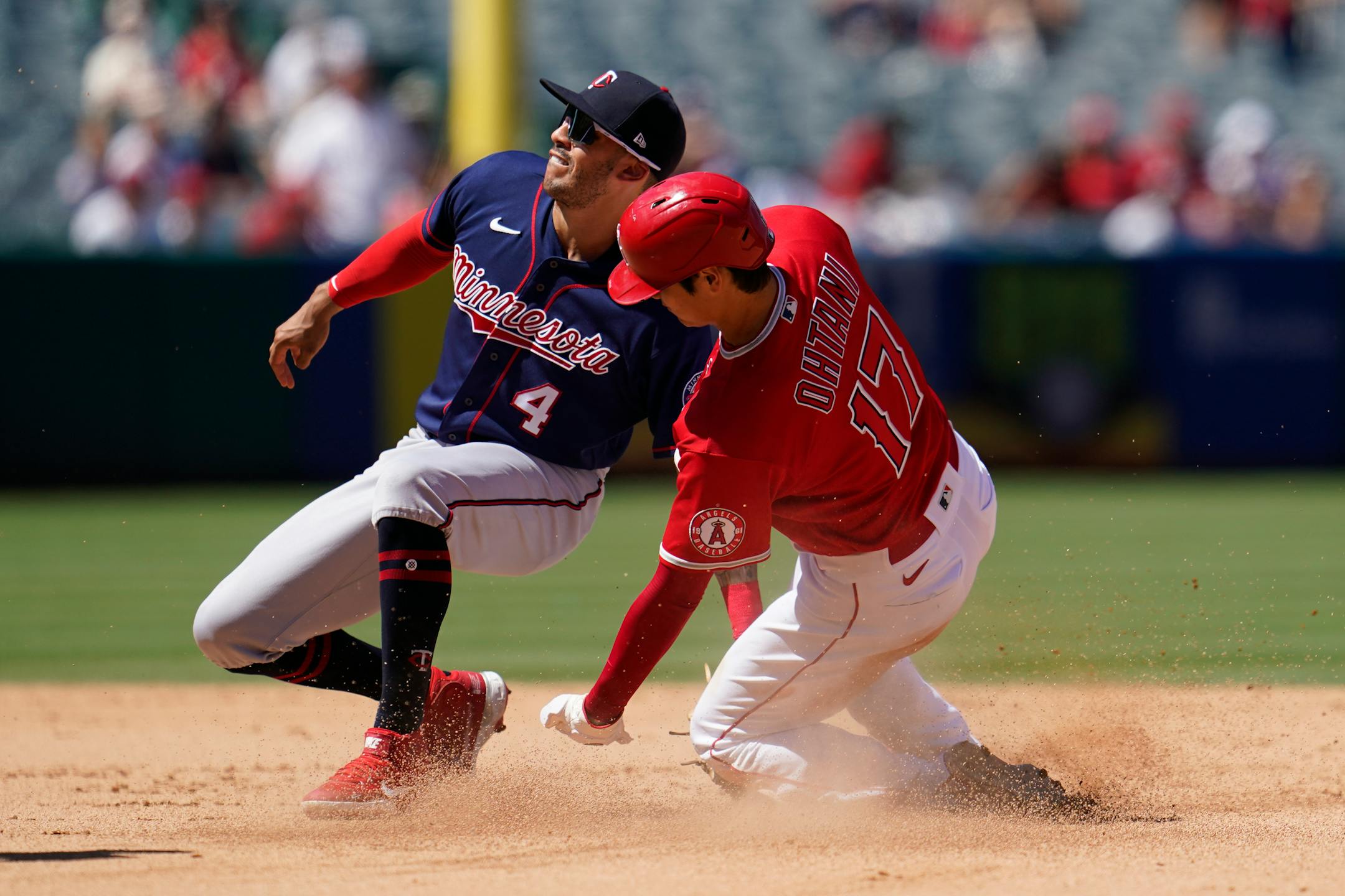 Minnesota Twins shortstop Carlos Correa, left, tags out Los Angeles Angels' Shohei Ohtani at second base on a steal-attempt during the fifth inning of a baseball game Sunday, Aug. 14, 2022, in Anaheim, Calif. (AP Photo/Marcio Jose Sanchez)