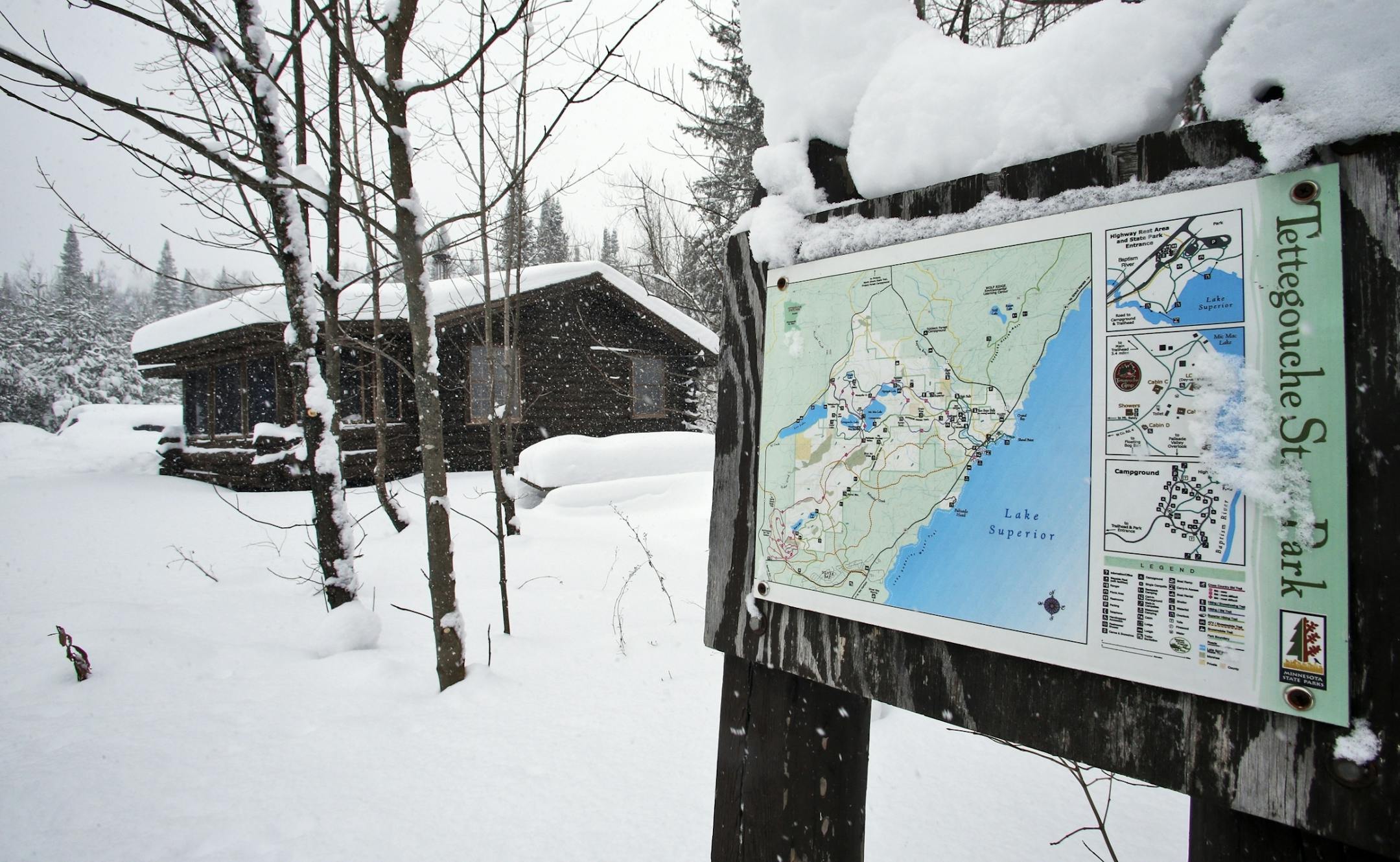 A park trail map with a rental cabin in the background.