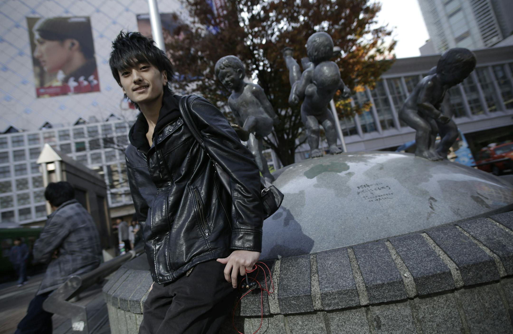 In this Friday, Nov. 21, 2014 photo, Yuto Tanaka, a college student, poses for a portrait in Shibuya shopping district in Tokyo. Japanese Prime Minister Shinzo Abe’s choice last week to postpone a sales tax hike to help fend off recession comes less as a relief than as cause for greater concern over how the country will cope with its ballooning national debt. Tanaka, 19, says he’s an Abe supporter and agrees that the tax hike should be put off. But in the longer run, Japan needs to