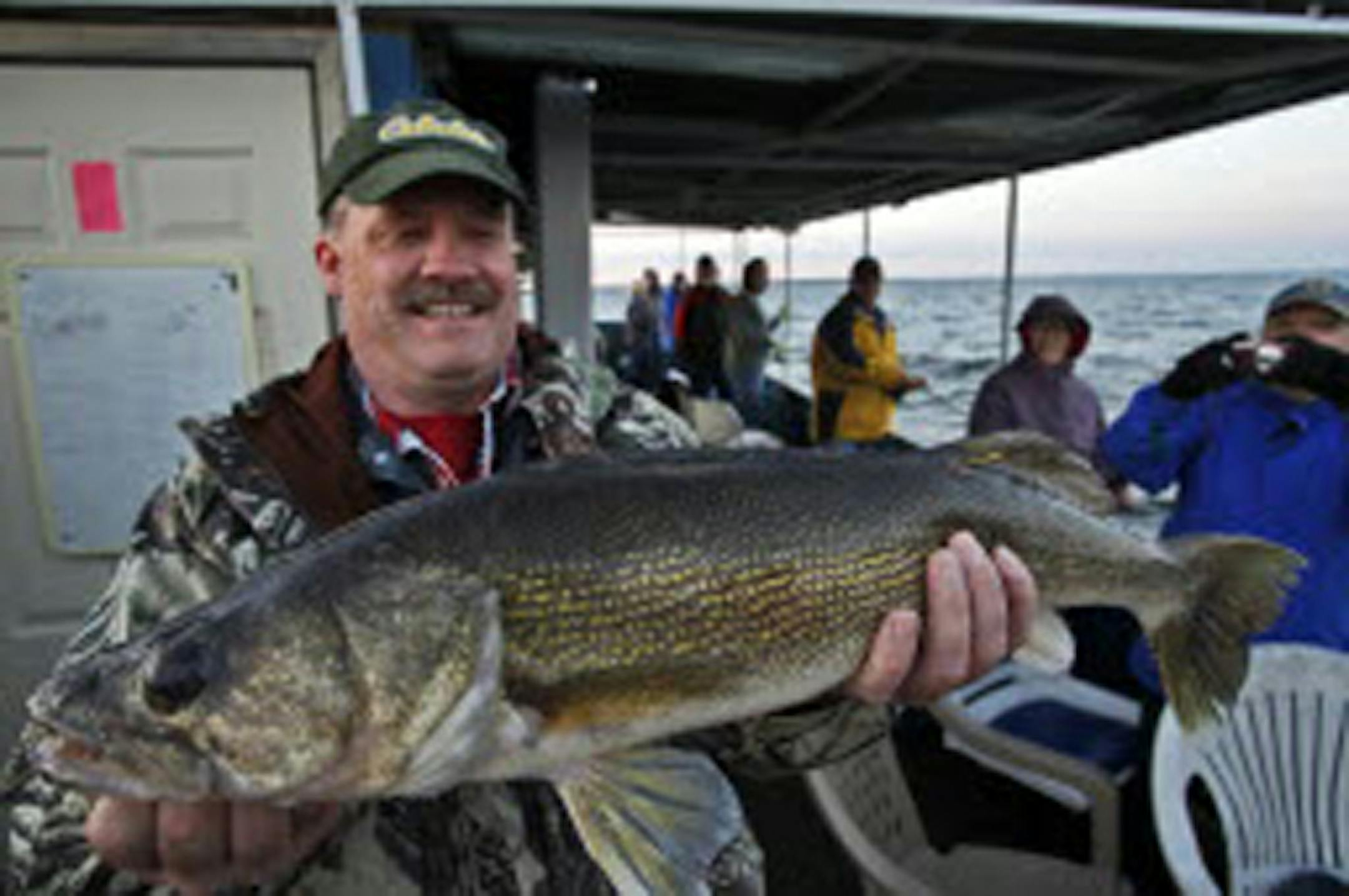 Jay Maher of St. Paul helds the 27-and three-quarter-inch walleye he hauled in while fishing from a launch boat operated by Twin Pines Resort on Lake Mille Lacs. Walleye fishing regulations are being tightened on Mille Lacs, Minnesota's most popular walleye lake, to prevent overharvest.