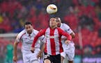 Athletic Bilbao's Aritz Aduriz, left, duels for the ball with Sevilla's Timothee Kolodziejczak, during the quarterfinal first leg of the Europa League