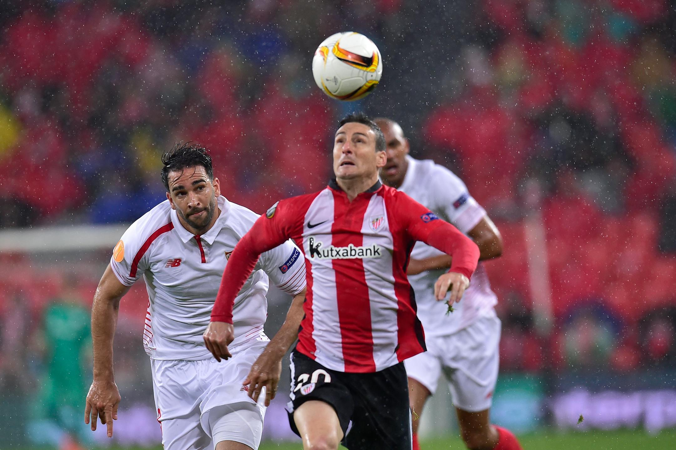 Athletic Bilbao's Aritz Aduriz, left, duels for the ball with Sevilla's Timothee Kolodziejczak, during the quarterfinal first leg of the Europa League soccer match, between Athletic Bilbao and Sevilla, at San Mames stadium, in Bilbao, northern Spain, Thursday, April 7, 2016. Sevilla won the match 2-1. (AP Photo/Alvaro Barrientos)