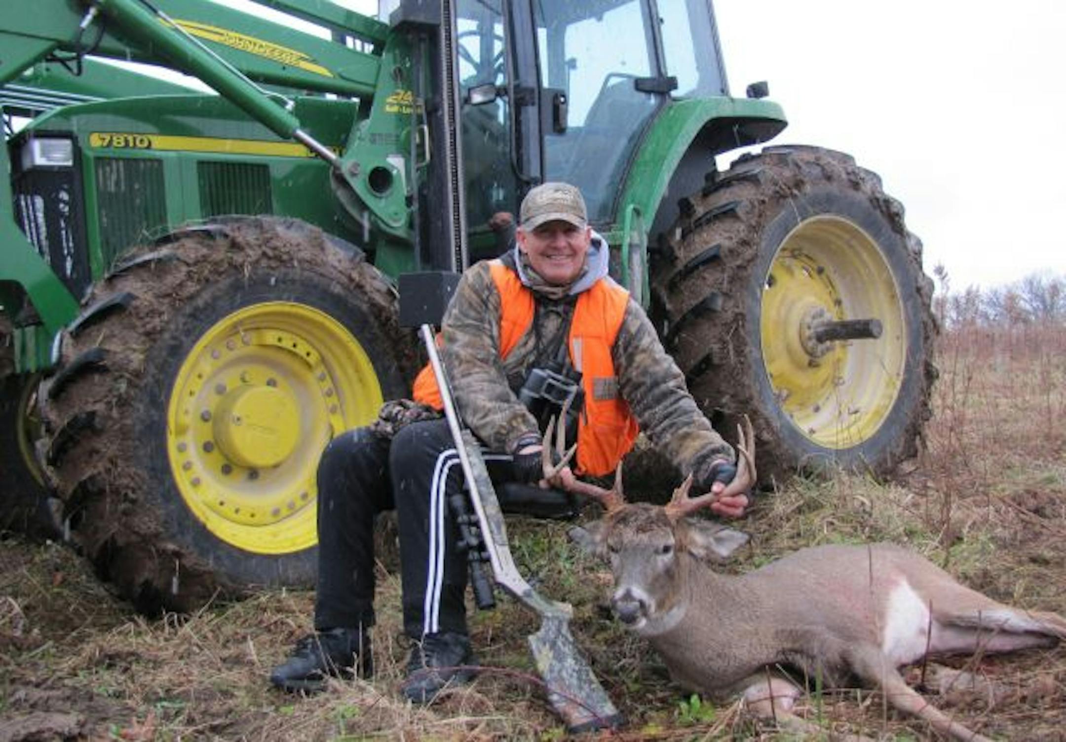 John Whalen posed with an 8-point buck he shot from his tractor's lift-chair. Whalen lost the use of his legs in 2008, but he still hunts deer and wild turkeys.