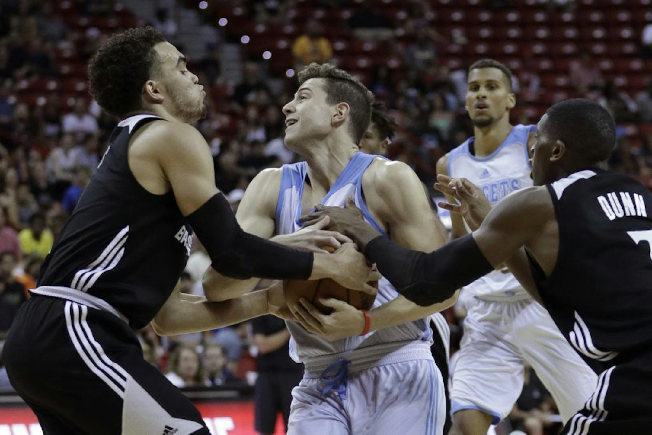 Minnesota Timberwolves' Tyus Jones, left, and Minnesota Timberwolves' Kris Dunn, right, try to get the ball from Denver Nuggets' Jimmer Fredette during the first half of an NBA summer league basketball game, Friday, July 8, 2016, in Las Vegas.