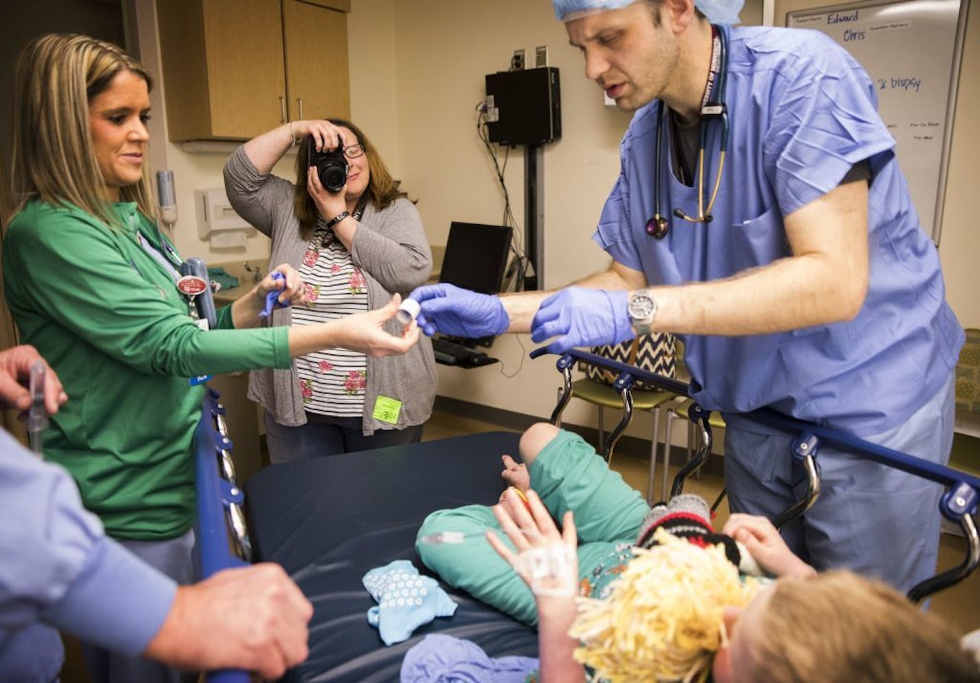 Christina Kunze takes photos of her son Eddie as he is readied to go in for a heart catheterization to check on his new heart.