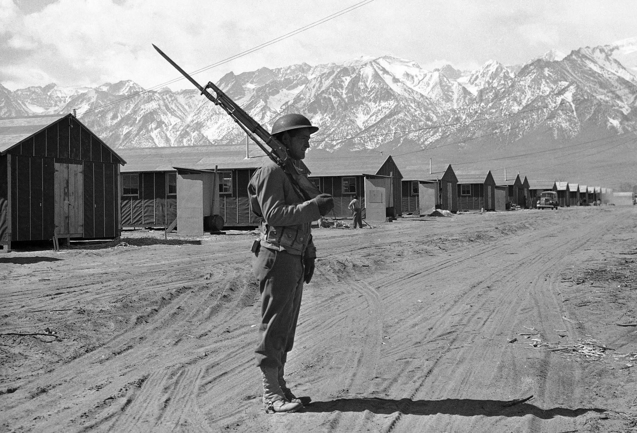 ADVANCE FOR MONDAY FEB. 20, FILE - This May 23, 1943 file photo shows an American soldier guarding a Japanese internment camp at Tule Lake, Calif. _ Seventy years have passed since Japanese Americans were shipped off to wartime camps _ and advocates are trying to stop time, if for a moment. The Japanese American National Museum is starting an online archive of personal stories from community members who survived the camps in the hopes of getting the now-octogenarian Nisei generation to share the