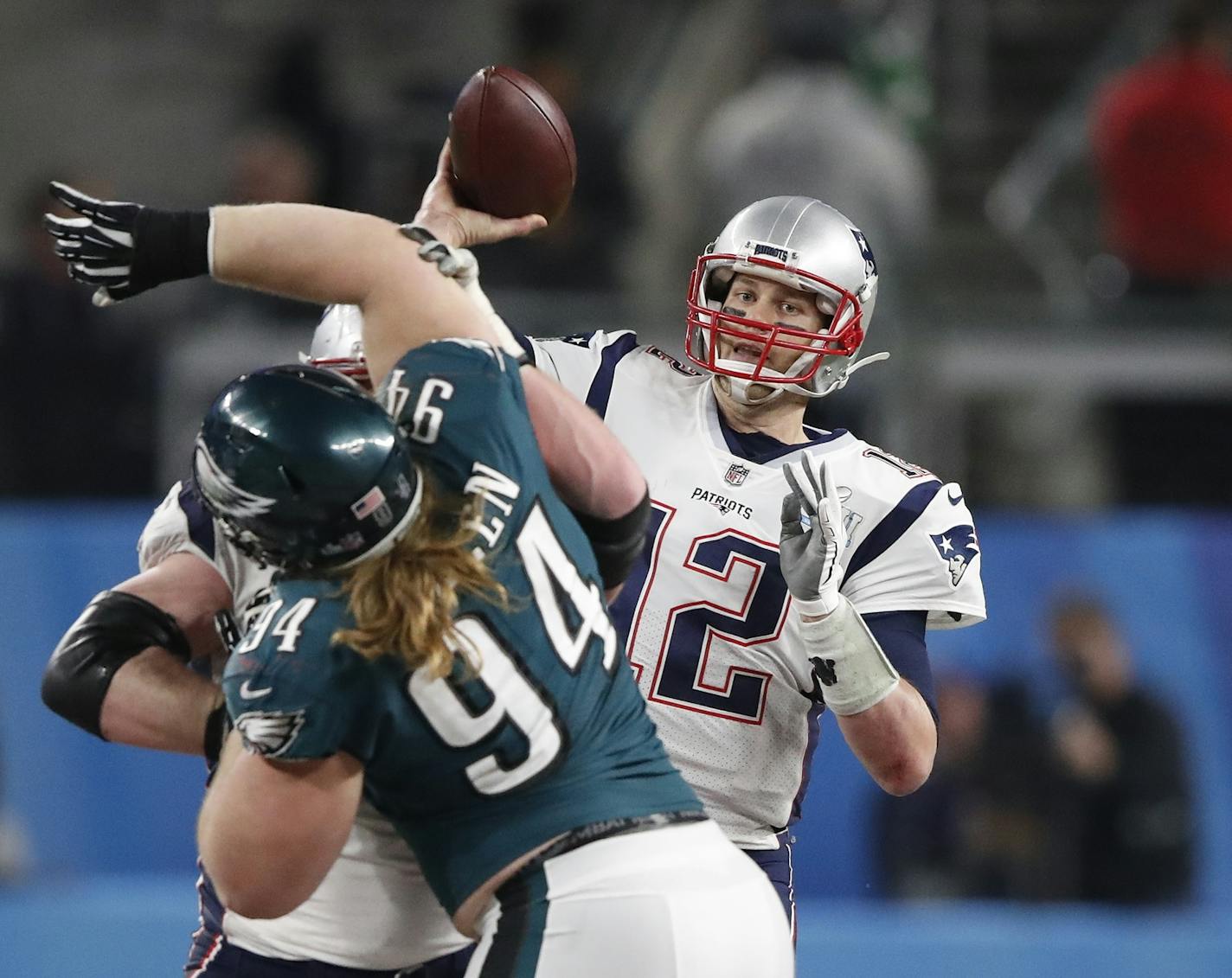 New England Patriots quarterback Tom Brady (12) threw a pass during Super Bowl LII as Beau Allen (94), a Minnetonka native who plays defensive tackle for the Philadelphia Eagles, put on the pressure.