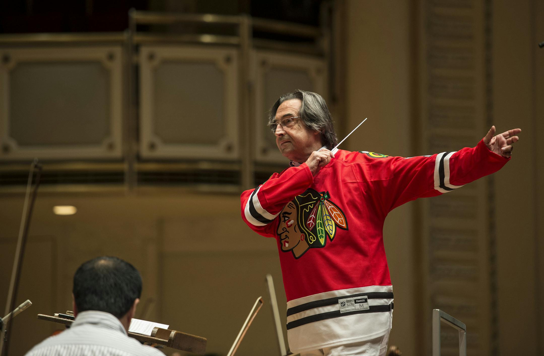 ADDS NAME OF MUSICAL DIRECTOR RICCARDO MUTI - Chicago Symphony Orchestra famed music director Riccardo Muti, wearing a Chicago Blackhawks jersey, leads the orchestra as it records "Chelsea Dagger" in honor of the Blackhawks Stanley Cup playoff run at Symphony Center on Wednesday, June 19, 2013 in Chicago. The performance was recorded and given to the team before Wednesday night's game against the Boston Bruins. (AP Photo/Chicago Symphony Orchestra, Brian Kersey) ORG XMIT: NY110