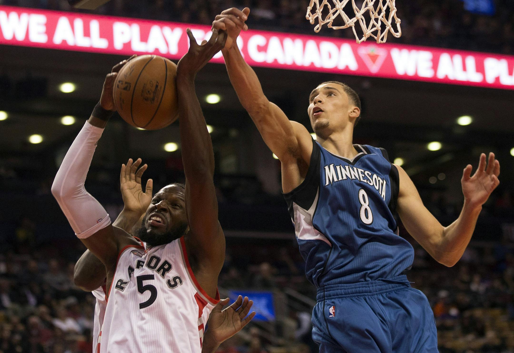 Toronto Raptors' DeMarre Carroll, left, claims a defensive rebound in front of Minnesota Timberwolves' Zach LaVine during the first half of an NBA preseason basketball game Monday, Oct. 12, 2015, in Toronto. (Chris Young/The Canadian Press via AP) MANDATORY CREDIT