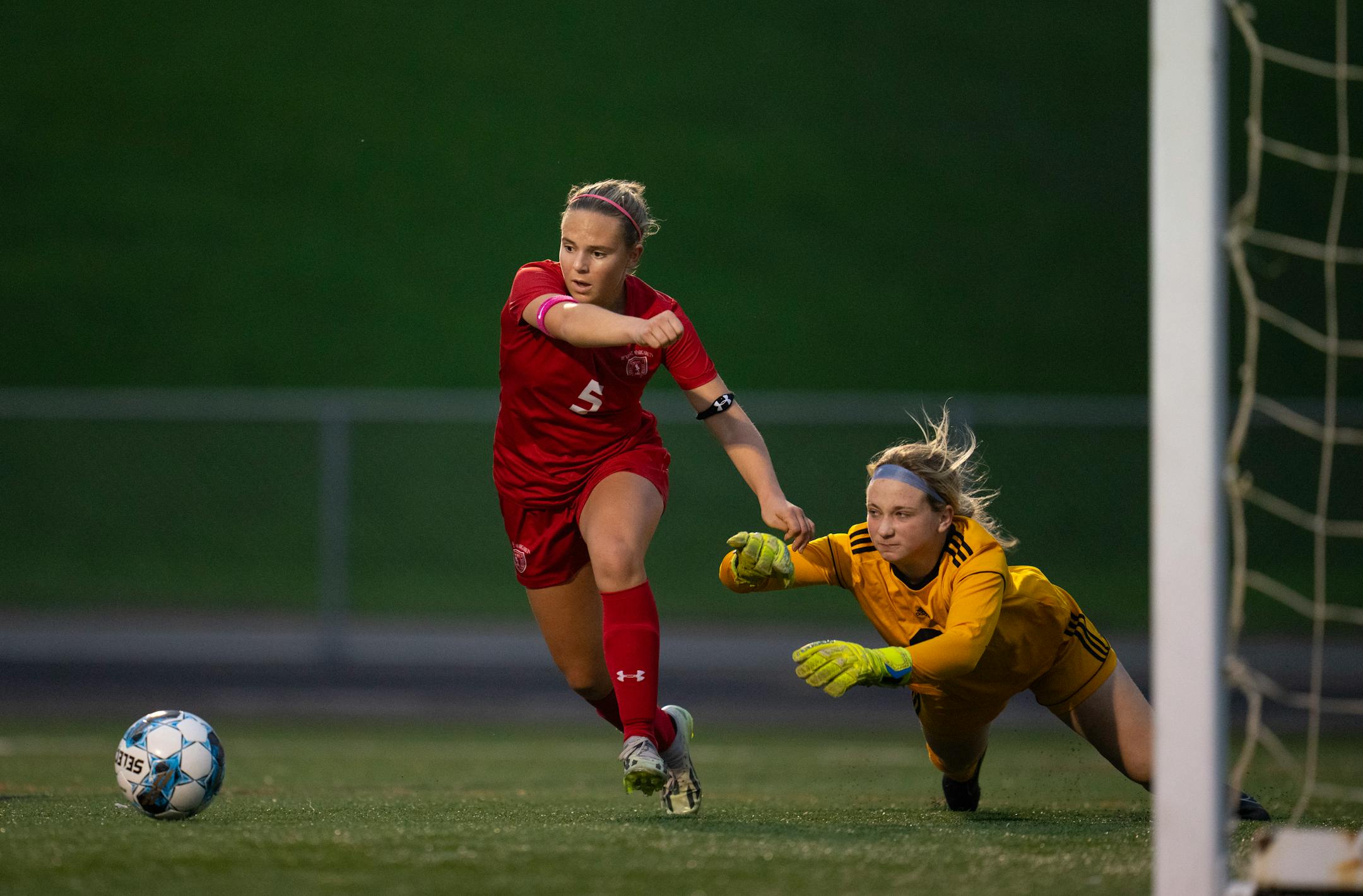 Benilde-St. Margaret's Hannah Buller (5) and Mankato East keeper Ashley Fischer battled for control of the ball in front of the net in the first half.