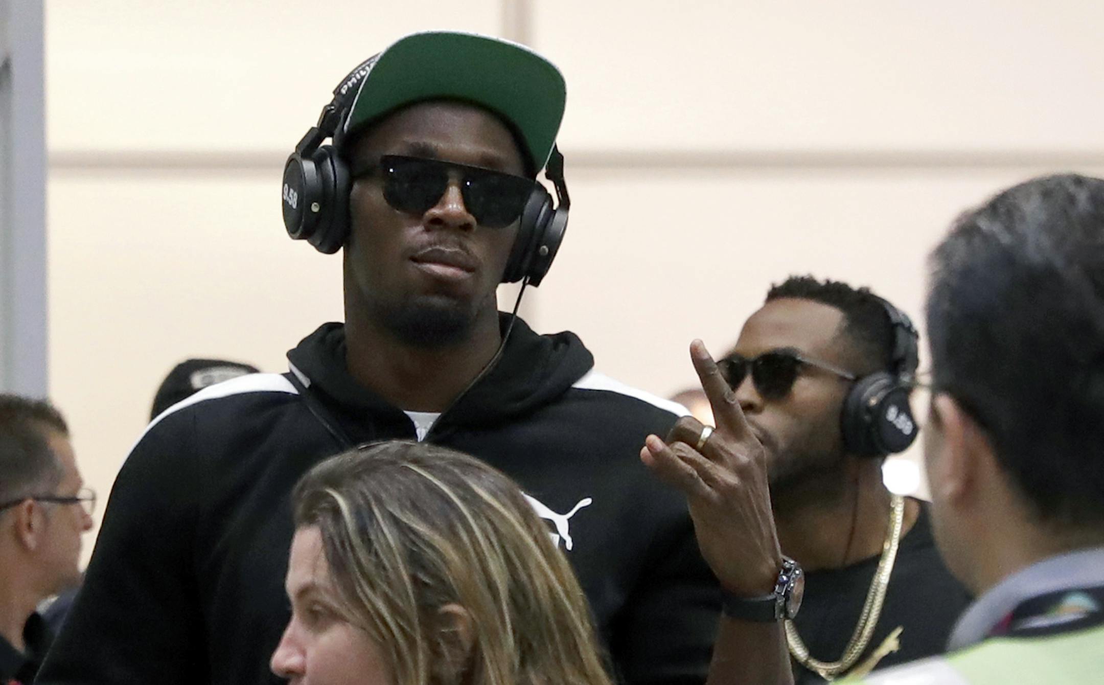 FILE - In this July 27, 2016 file photo, Jamaican Olympic runner Usain Bolt, center, gestures while arriving at Rio de Janeiro International Airport in Rio de Janeiro, Brazil. Bolt made his first major appearance Monday, Aug. 8 in Rio de Janeiro leading up to the Olympics, talking about his desire to break 19 seconds in the 200 meters, then ending his engaging news conference by boogieing offstage, accompanied by more than a dozen near-naked Samba dancers. (AP Photo/Patrick Semansky, File)