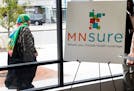 In this Oct. 26, 2017, photo, a woman walks past the Briva Health enrollment office for MNsure, Minnesota's insurance marketplace, in Minneapolis.