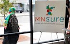 In this Oct. 26, 2017, photo, a woman walks past the Briva Health enrollment office for MNsure, Minnesota's insurance marketplace, in Minneapolis.