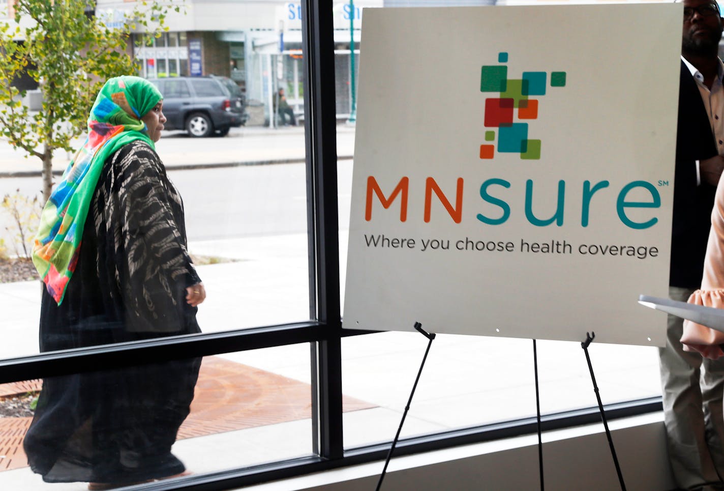 In this Oct. 26, 2017, photo, a woman walks past the Briva Health enrollment office for MNsure, Minnesota's insurance marketplace, in Minneapolis.