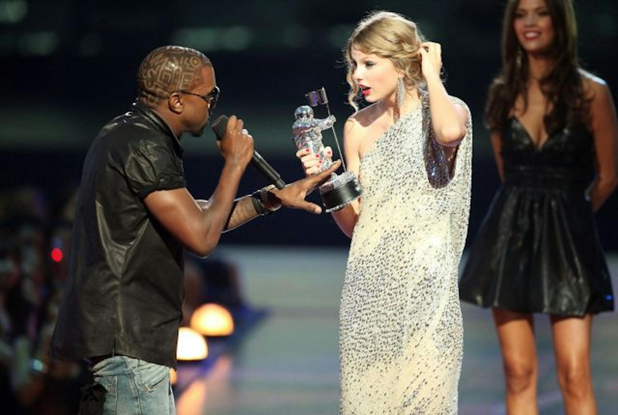 Kayne West (L) jumps onstage after Taylor Swift (C) won the "Best Female Video" award during the 2009 MTV Video Music Awards at Radio City Music Hall on September 13, 2009 in New York City.