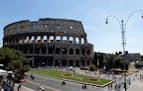 Tourists walk in front of Rome's Colosseum, Tuesday, July 31, 2012. Italian cultural officials say a euro 25 million (30-million dollars) restoration 