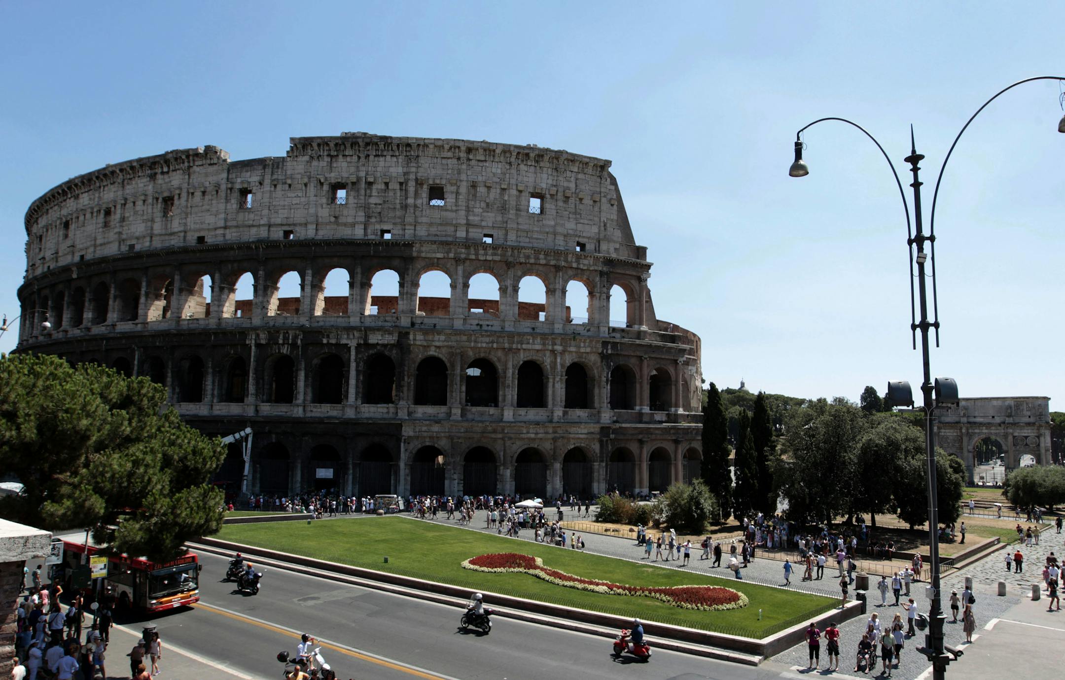 Tourists walk in front of Rome's Colosseum, Tuesday, July 31, 2012. Italian cultural officials say a euro 25 million (30-million dollars) restoration of the Colosseum being paid for by founder of luxury shoemaker Tod's Diego Della Valle, will begin in December. Officials announced Tuesday that the work is expected to take 2 1/2 years. The ancient Roman arena has been blackened by pollution and rocked by vibrations from a nearby subway line. (AP Photo/Gregorio Borgia)