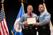 Sergeant Jeremy Depies poses with Minneapolis Police Chief Brian O’Hara after he was awarded a medal of valor for rescuing a drowning four-year-old 