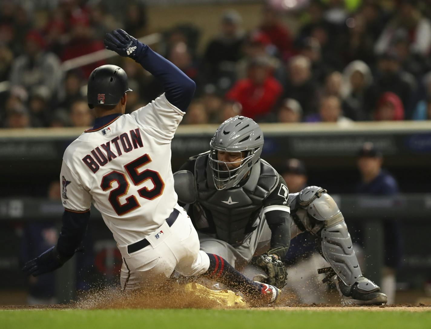 Minnesota Twins center fielder Byron Buxton (25) was safe at home when Chicago White Sox catcher Omar Narvaez (38) couldn't handle the throw from Chicago White Sox shortstop Tim Anderson (7) after he fielded a hit by Brian Dozier.