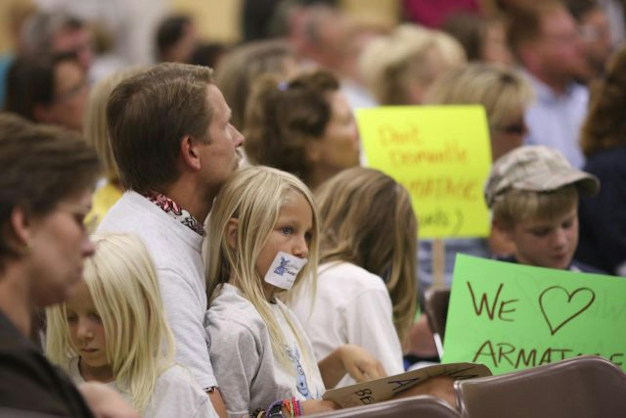 Oskar Robinson, 8, sat on the lap of his dad, Paul Robinson while listening to comments from the public. Oskar attended to show support for his school, Armatage.