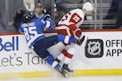 Winnipeg Jets' Mathieu Perreault (85) and Detroit Red Wings' Mike Green (25) collide during the first period of an NHL hockey game Friday, Jan. 11, 20