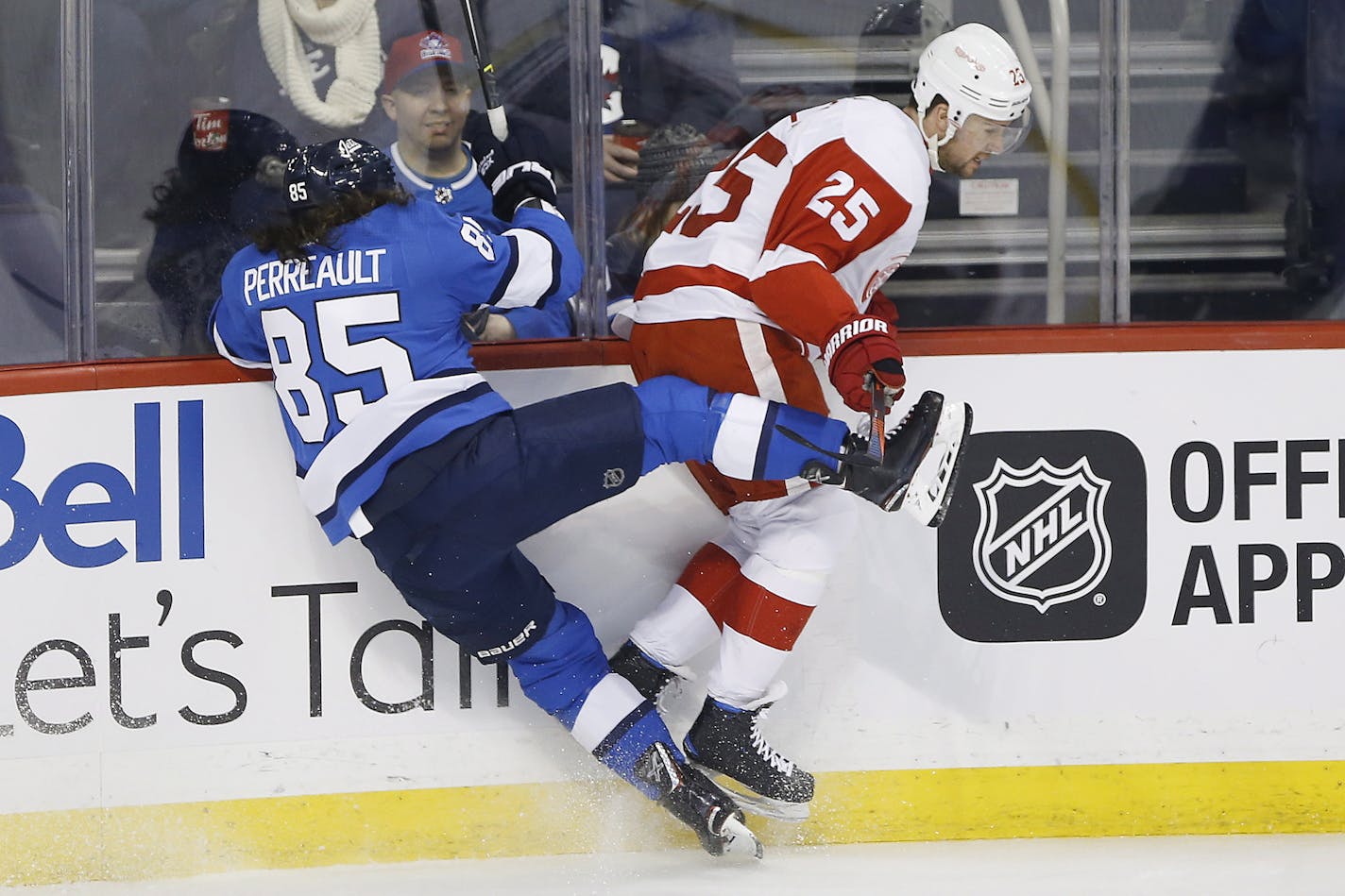 Winnipeg Jets' Mathieu Perreault (85) and Detroit Red Wings' Mike Green (25) collide during the first period of an NHL hockey game Friday, Jan. 11, 2019, in Winnipeg, Manitoba. (John Woods/The Canadian Press via AP)