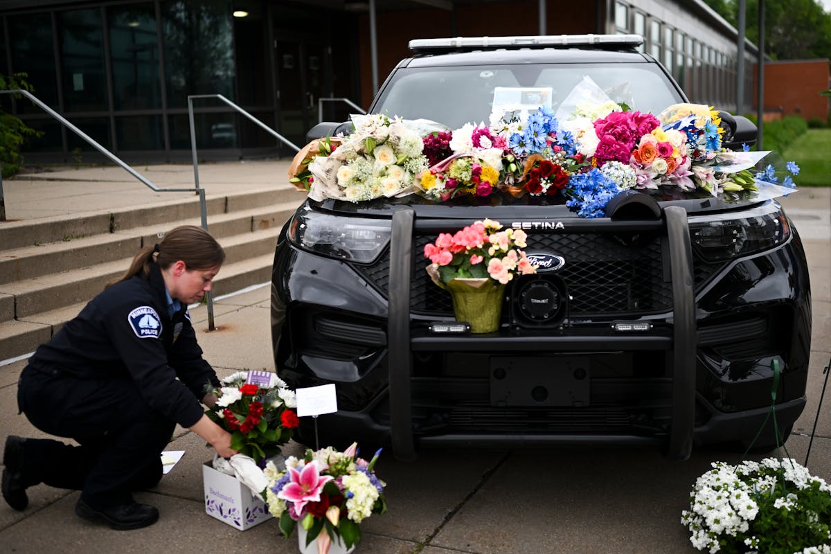 Minneapolis police officer Nicole MacKenzie brings flowers down to a memorial for fallen officer Jamal Mitchell on Friday outside the Fifth Precinct.