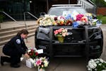 Minneapolis Police Officer Nicole MacKenzie brings flowers down to a memorial for fallen officer Jamal Mitchell on May 31 outside the Minneapolis Poli