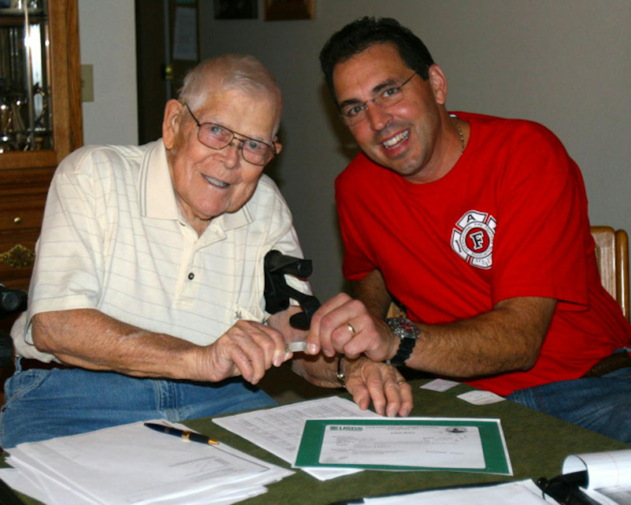Forest Strnad and Todd Rost hold the recovered band from Barred Owl numbered 0667-95412.