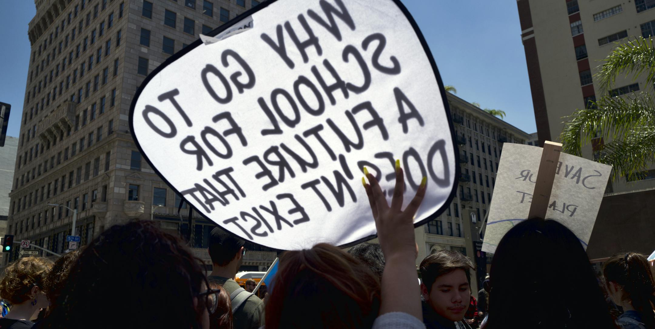 A climate change activist holds a sign that reads "Why Go To School For a Future that Doesn't Exist" during a protest rally at Pershing Square in downtown Los Angeles on Friday, May 24, 2019. (AP Photo/Richard Vogel)