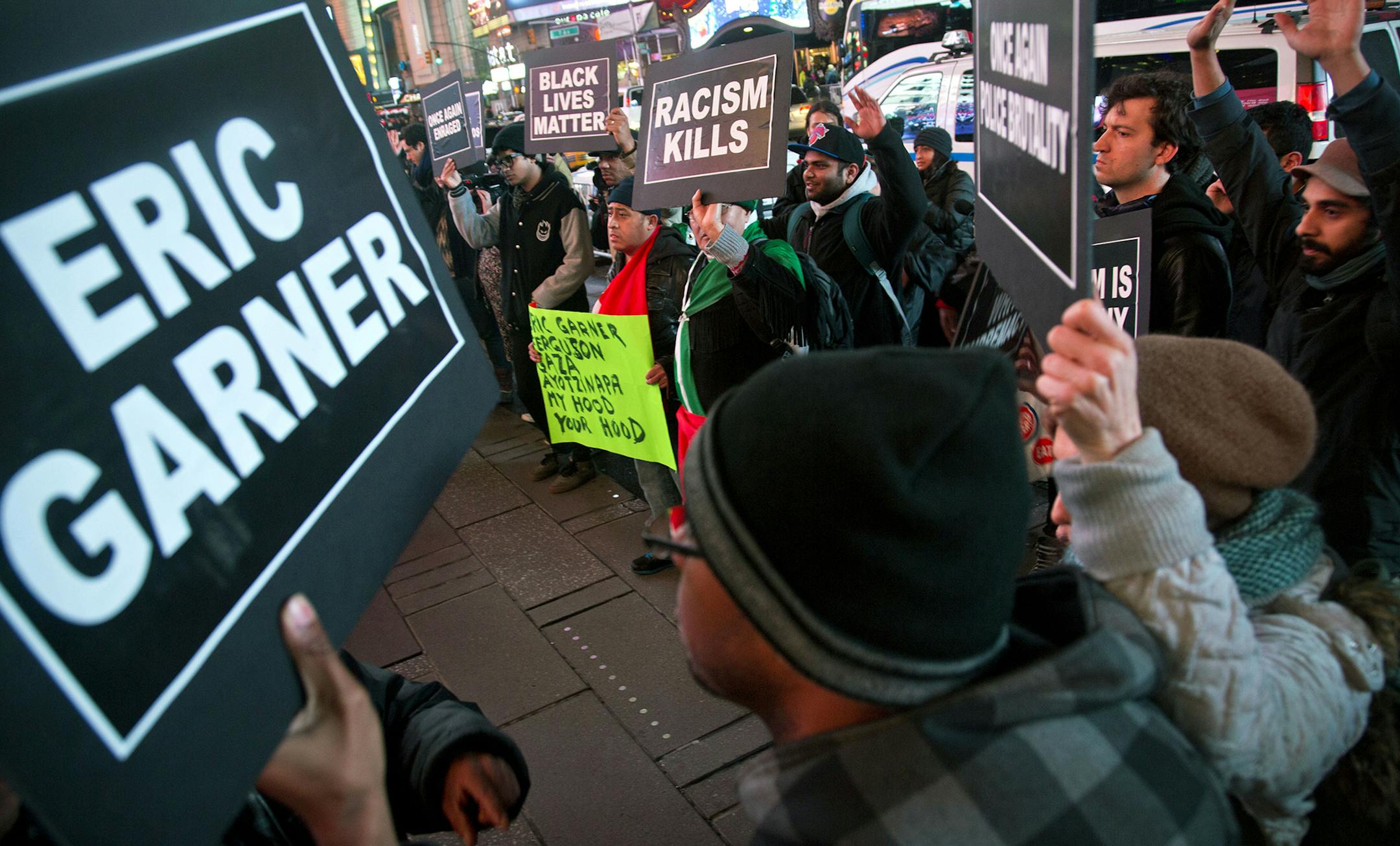 Protesters in Times Square raise their hands and chant while carrying signs in reaction to a non indictment against a police officer in the death of Eric Garner, Wednesday Dec. 3, 2014, in New York. (AP Photo/Bebeto Matthews) ORG XMIT: NYBM103