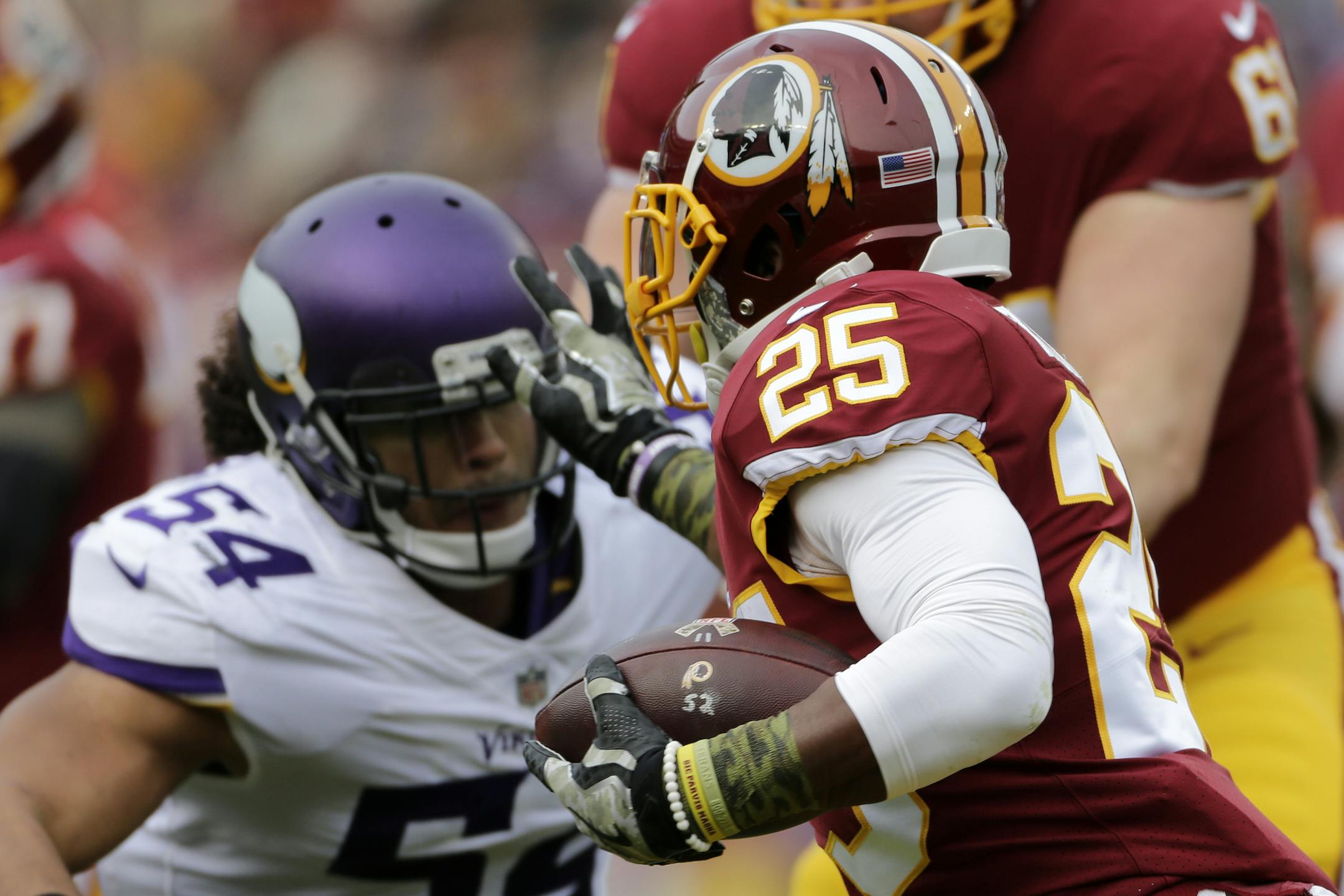 Washington Redskins running back Chris Thompson (25) stiff arms Minnesota Vikings middle linebacker Eric Kendricks (54) during an NFL football game between the Minnesota Vikings and Washington Redskins, Sunday, Nov. 12, 2017, in Landover, Md. (AP Photo/Mark Tenally)