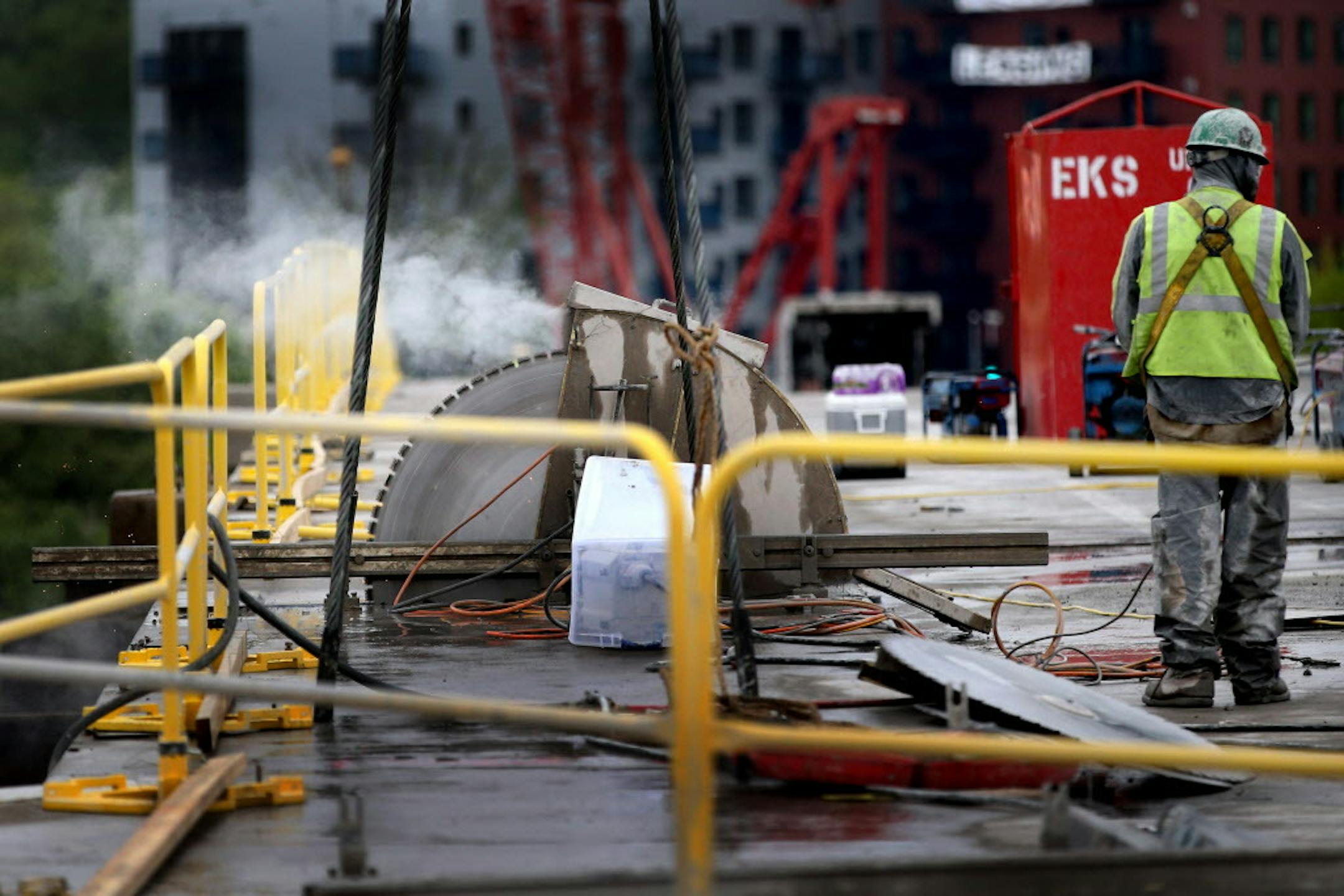 A giant saw that can be remotely operated cuts through 12 plus-inch concrete roadway on the Franklin Avenue Bridge Tuesday, May 10, 2016, in Minneapolis MN. Each concrete panel is 12 feet wide and 28 feet long and weighs about 25 plus tons or about 13 times what a typical motor vehicle weighs and is loaded down to an awaiting barge. Construction on the bridge, which began with bridge undercarriage repair in February of 2015, is expected to be completed by June of 2017. The bridge will reopen for