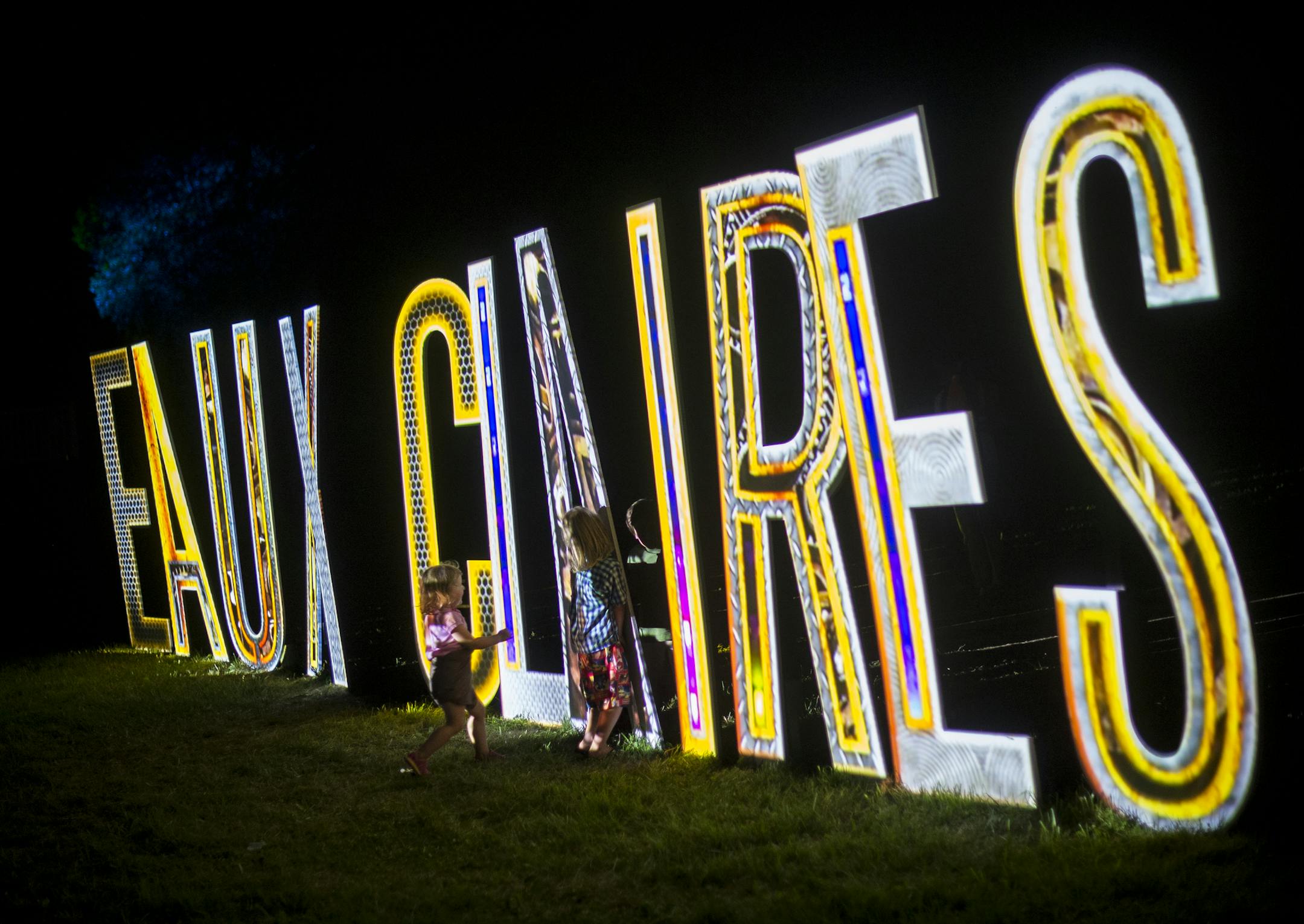Children played by the illuminated Eaux Claires sign Saturday night during Bon Iver's set. ] Aaron Lavinsky &#x2022; aaron.lavinsky@startribune.com The Eaux Claires Music & Art Festival was photographed Saturday, July 18, 2015 in Eau Claire, WI.