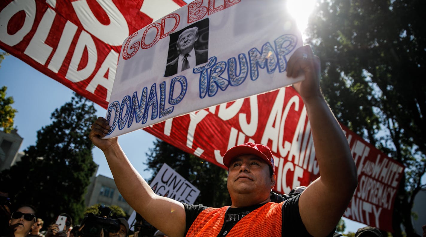 A supporter of President Donald Trump holds up a sign amid protesters against racism at Martin Luther King Park in Berkeley, Calif., on Sunday, Aug. 27, 2017. (Marcus Yam/Los Angeles Times/TNS) ORG XMIT: 1209748 ORG XMIT: MIN1708271900323249